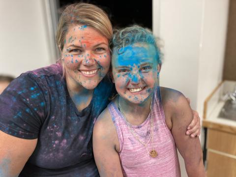A PTA mom and a student covered in chalk after the chalk fight