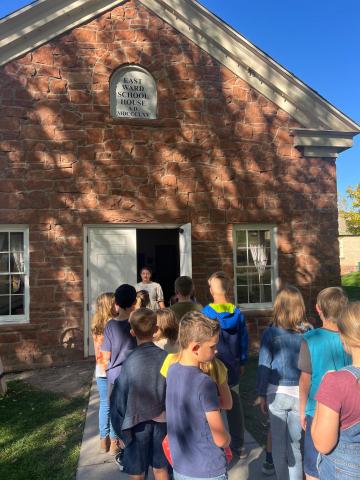 4th grade students standing in front the school house  at This is the Place Heritage Park