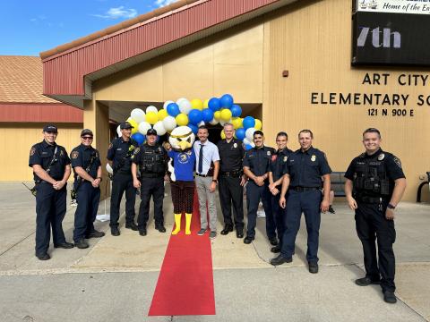 Police officers, Ace the Eagle, and Mr. Cornwall on the red carpet welcoming students
