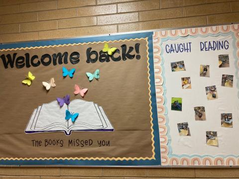 Library Bulletin Board of pictures of students of various ages caught reading and "Welcome Back! The books misses you!"