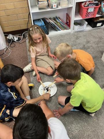 second grade students examining worms