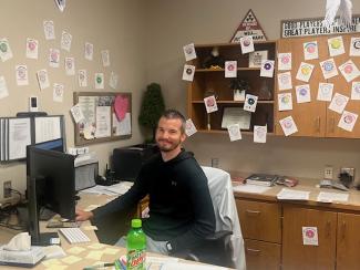 Mr. Cornwall sitting in his office surrounded by notes of appreciation