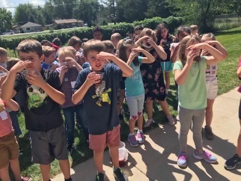 Second Grade students pinching their nose as they drink freckle juice