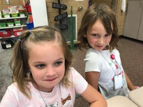 Two second grade girls with purple freckles