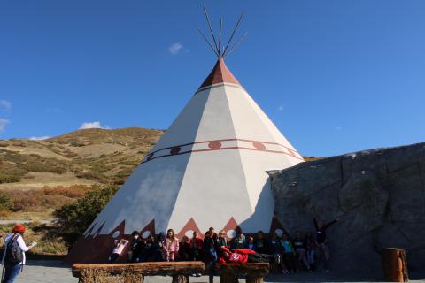 A group of students standing in front of a Tepee