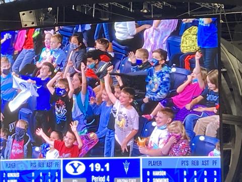 Students at a BYU Women's Basketball game on the Jumbo Tron