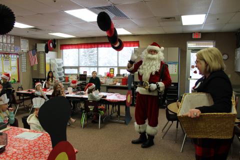 Santa and Mrs. Muirbrook visiting the North pole, students at their train desks