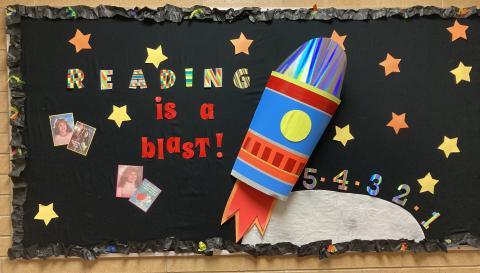 Library Bulletin Board Reading is a Blast with 5th grade teachers pictures as they looked in 5th grade