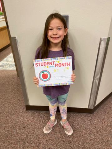 Stand strong student holding their Student of the month certificate