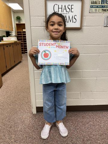 Stand strong student holding their Student of the month certificate