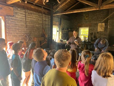 4th grade students watching the Black Smith at This is the Place Heritage Park