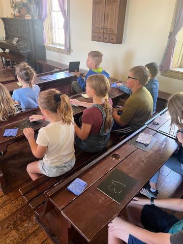 4th grade students sitting in the school house at This is the Place Heritage Park