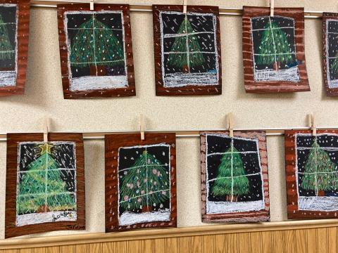 Multiple Students artwork of a Christmas tree through a cabin window