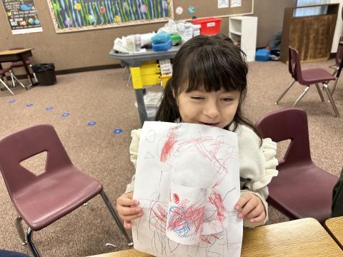 Student proudly holding her 3-D Art 