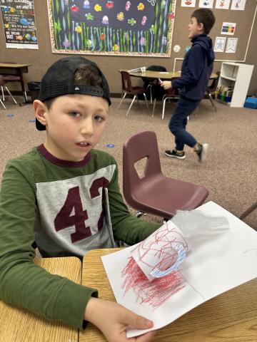 Student proudly holding his 3-D Art 