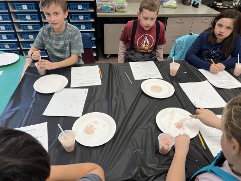 Students working on their experiment, mixing up ingredients. 