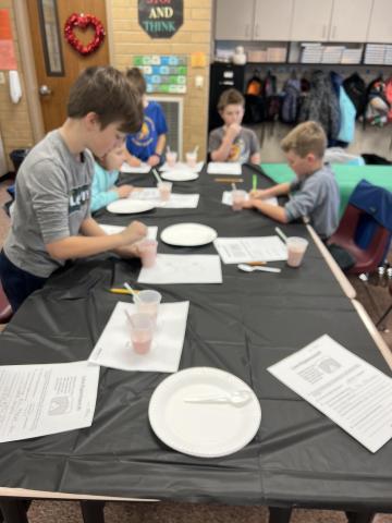 Students working on their experiment, mixing and writing.