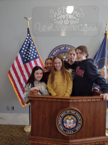 Students standing at a pulpit in the Capitol building 