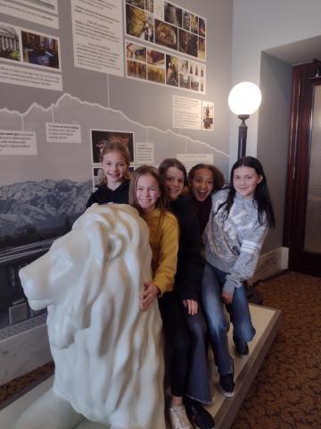 Students sitting on a marble lion