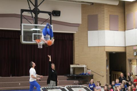 Member of the Dunk team soaring through the air over Mrs. Huffaker