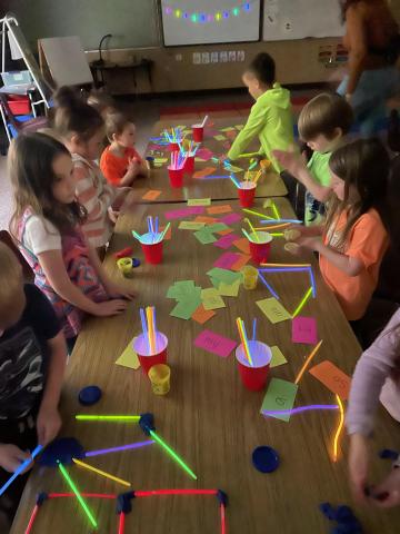 Students using glow sticks to build a craft.