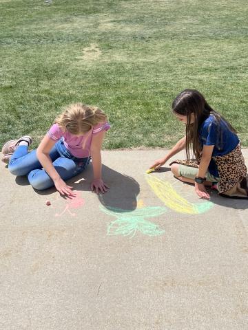 two students drawing flowers and creatures
