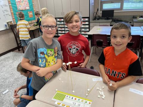 Three students showing what their team created