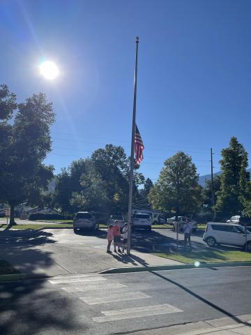 Three fifth-grade students raising the flag
