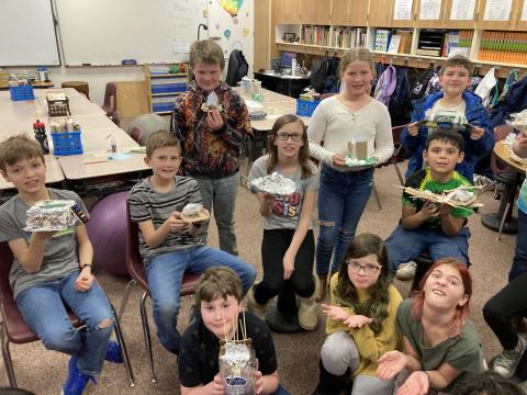 Students holding their models their home 