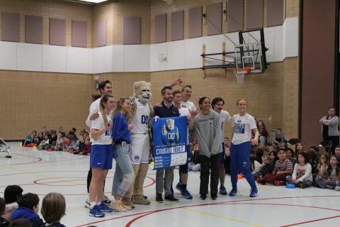 BYU Athletes, the BUY Dunk team and mr. Cornwall holding up a Cougar Built sign 