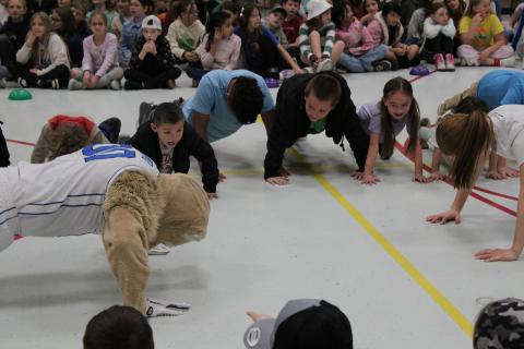 Cosmo, BYU Athletes and students showing strength by doing push-ups. 