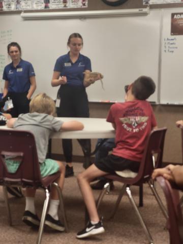 Living Aquarium teacher showing students a snake