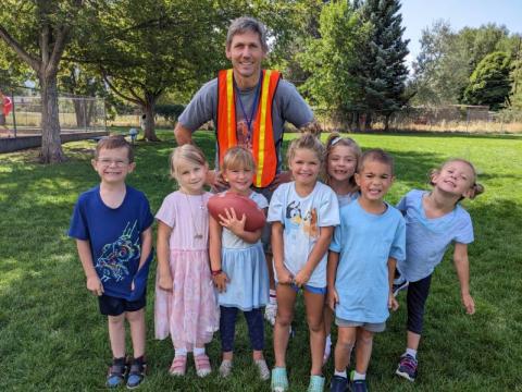 A dad with a group of children during lunch 