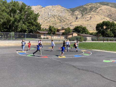 Students playing a game on the circle with shapes.