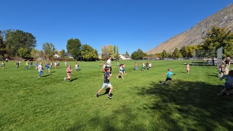 Kindergarten students running with Conner Mantz