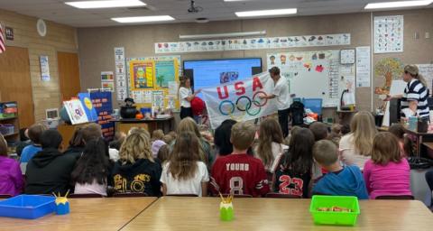 Conner Mantz and Mrs. Mantz holding the Olympic Flag