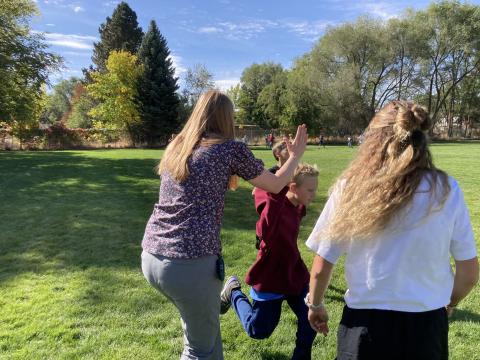 Miss Wood giving high five to a student as he finishes shortly behind Conner