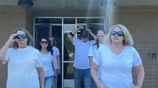 Office staff strutting out of the building with sunglasses on
