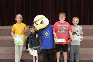 Four students with ACE the eagle