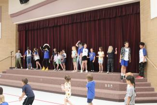 Student council and a few students dancing while waiting for all of the students to arrive in the gym