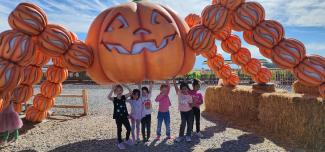 Students standing under a Pumpkin Spider