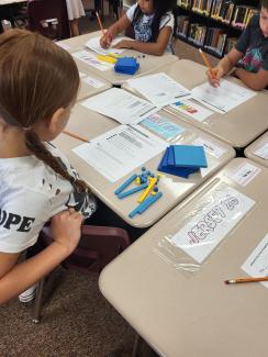 Students sitting at their desks using math manipulatives